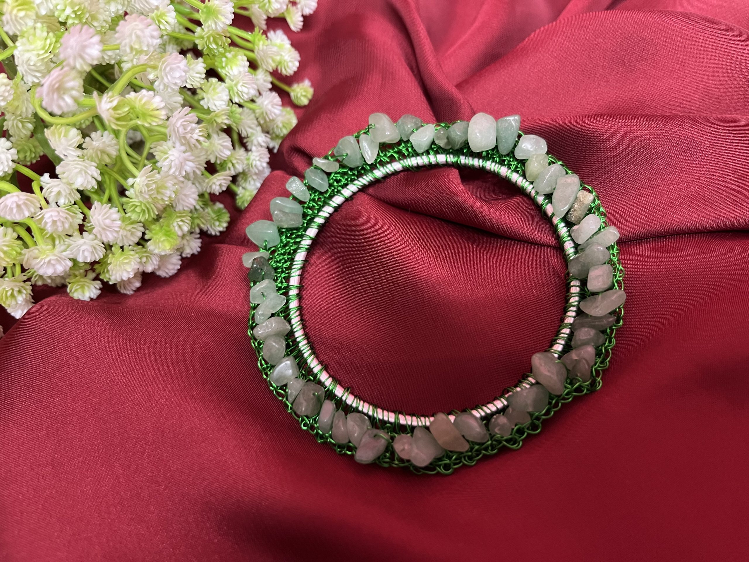 This Gemstone Bangle blends hand-crocheted stainless steel with authentic gemstones on a lightweight aluminium base. The matte finish and artistic stone arrangement create a contemporary bohemian look. Choose your preferred gemstone and wrist size for a personalised piece. Crafted in the UK with hypoallergenic materials for all-day comfort.